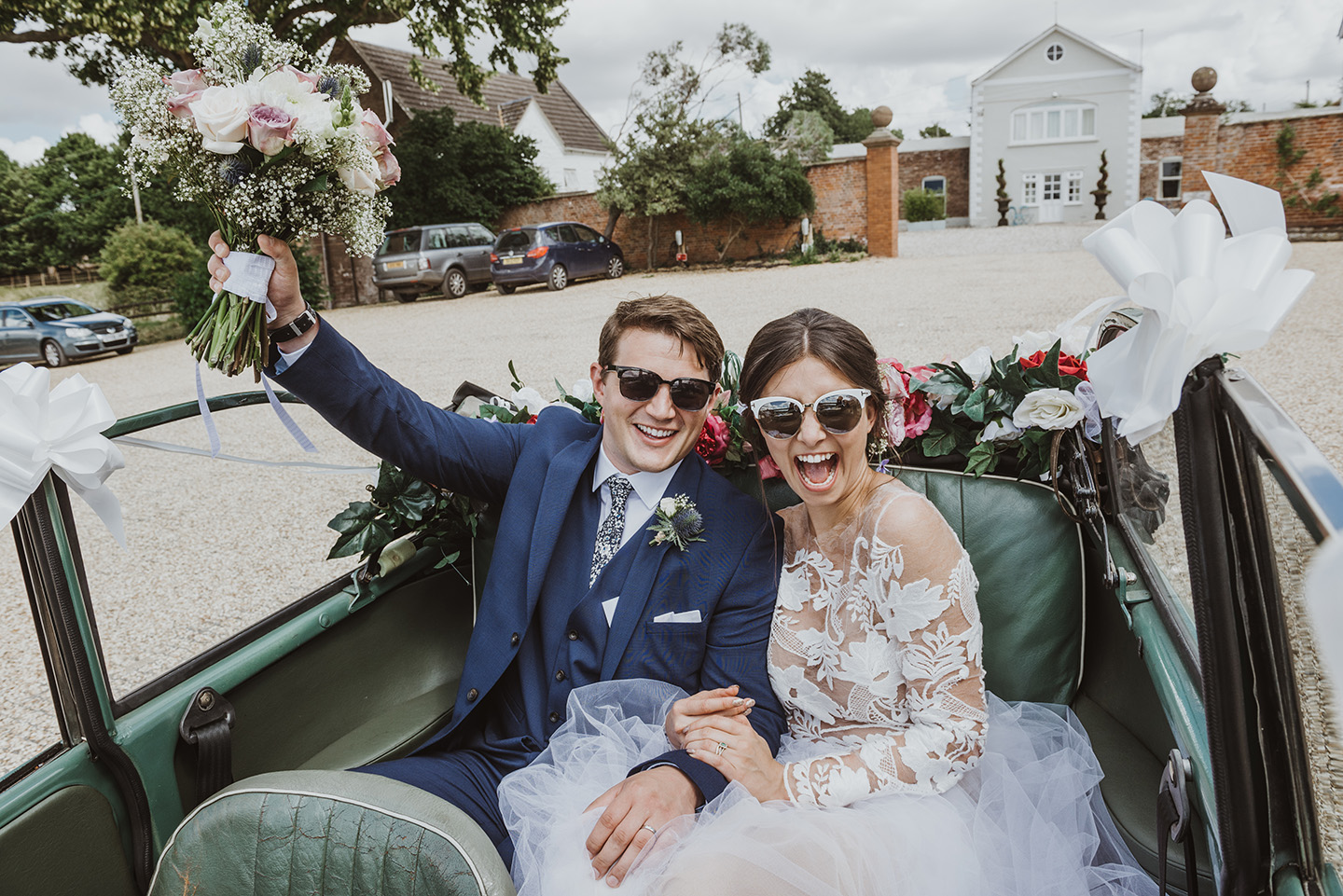 happy newlywed couple in a morris minor at a Herefordshire wedding venue by Birmingham wedding photography byGarazi